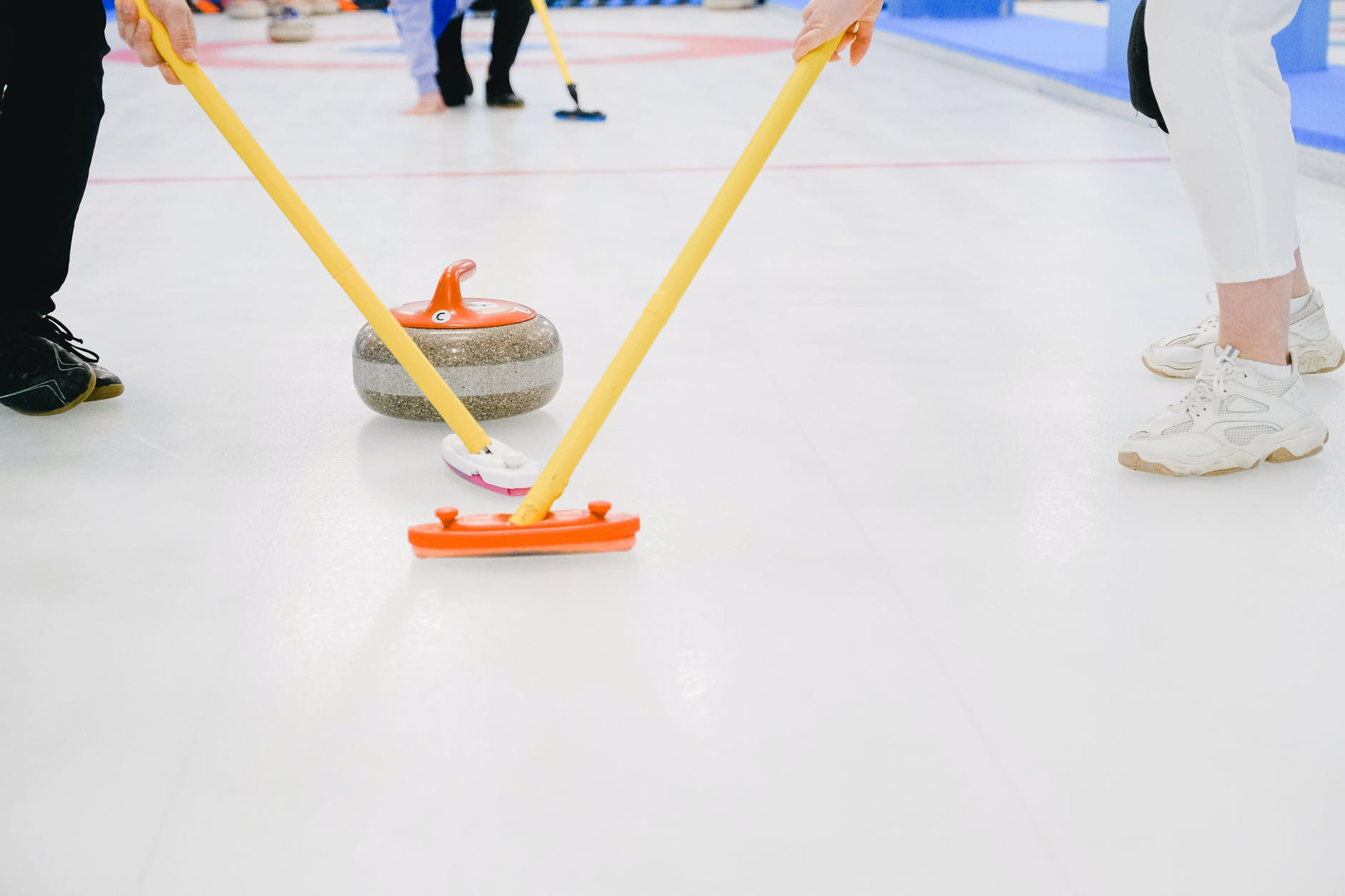 unrecognizable team playing curling on ice